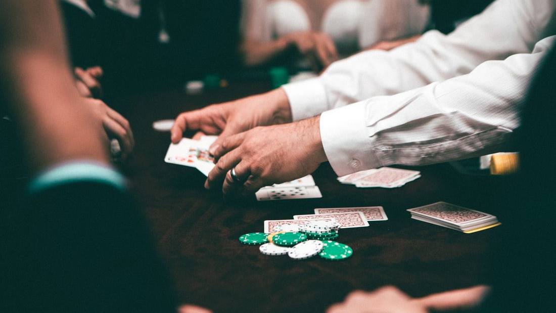 Kartu remi dan chip di atas meja poker hijau